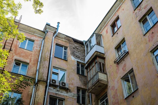 Со стены дома в центре Твери на выходящих из подъезда людей падают кирпичи